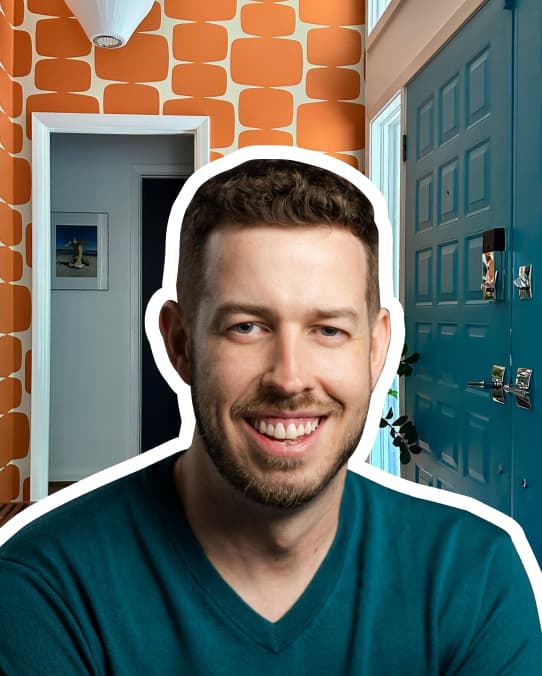 Headshot of Christopher Matos-Rogers, who is smiling and wears a turquoise v-neck sweater. He has short curly hair and short facial hair. His headshot is outlined with a white border, and the background is the entryway of a home. The walls are covered in an orange patterned wallpaper, and the door is a turquoise blue.